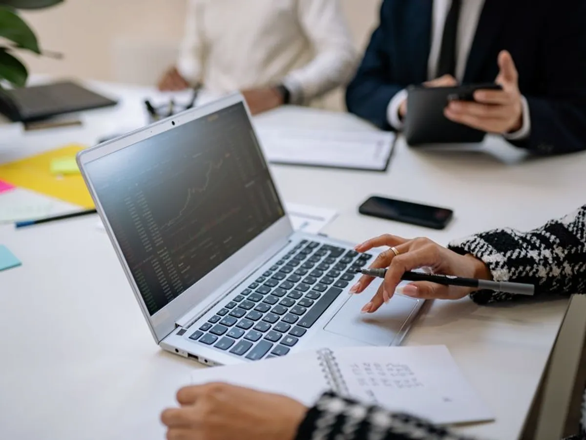 Equipo revisando datos de negocio en una laptop durante una reunión